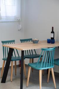 雷夫卡达镇Fragiato Apartment的一张木桌,四周摆放着两把蓝色椅子