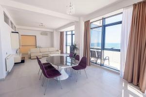 马马亚海滨住宅公寓酒店的客厅配有玻璃桌和椅子