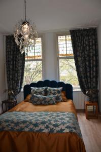 海牙Huize Maurits的一间卧室设有一张床和两个窗户。