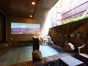 御殿场市Dormy Inn Express Fujisan Gotemba的大楼内的热水浴缸,配有电视