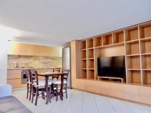 利多迪卡马约雷Sole apartment的厨房以及带桌子和电视的用餐室。