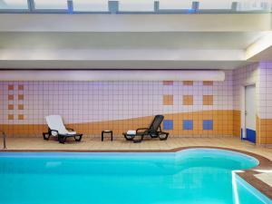 普瓦捷普特瑞斯爱达格公寓式酒店的一个带两把椅子的游泳池和一个游泳池