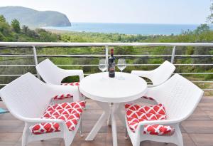 佩特罗瓦纳莫鲁Apartments Siljak的阳台上配有白色的桌椅,享有海景