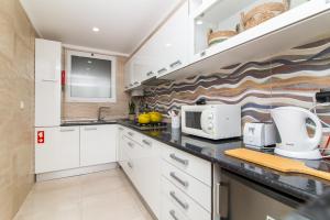 阿尔布费拉Açoteias B3的厨房配有白色橱柜和微波炉