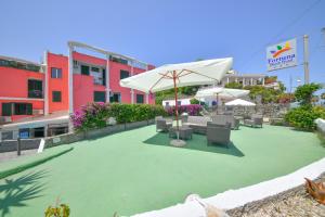 伊斯基亚Fortuna Beach - Seaside Hotel的草坪上带椅子和遮阳伞的天井