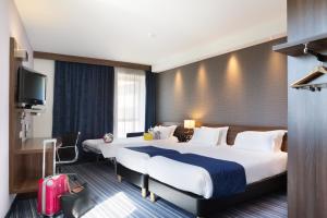 土伦Holiday Inn Express Toulon - Est, an IHG Hotel的酒店客房设有两张床和电视。