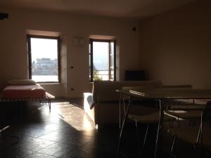 奥尔塔圣朱利奥Casa Vacanza Piazza的带沙发和桌子的客厅以及2扇窗户。