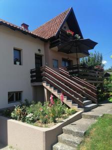 巴伊纳巴什塔Putnicka kuca kod Dragane的一座房子,设有楼梯,配有雨伞和鲜花