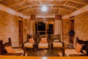 AkageraAkagera Transit Lodge的一间设有椅子和桌子的房间和砖墙