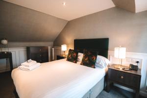 库勒The Seafield Arms-Cullen的一间卧室配有一张带两盏灯的大型白色床。