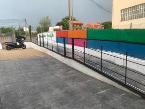 桑坦德ALOJAMIENTOS AVICHE 6的停在五颜六色围栏旁边的摩托车