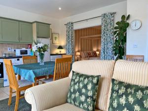 克利夫登Apartment 432 - Clifden的客厅以及带沙发和桌子的厨房。