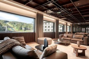 科帕奥尼克Hotel Grand Kopaonik的带沙发和大窗户的客厅