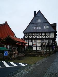 AltmündenBremer Handelshaus Fremdenzimmer的一座黑色和白色的古老建筑,有十字架
