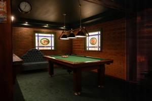比亚韦斯托克ApartHotel Hubertus的客房设有台球桌和彩色玻璃窗。