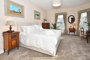 特伦特河畔斯托克The Sutherland Arms的卧室配有白色的床和桌椅