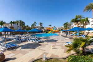 沙姆沙伊赫Naama Bay Hotel & Resort的一个带椅子和遮阳伞的游泳池以及滑梯