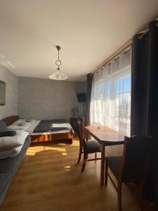 库瑞尼卡慕斯卡Twój Port的一间卧室配有一张床、一张桌子、一张床和一个窗户。