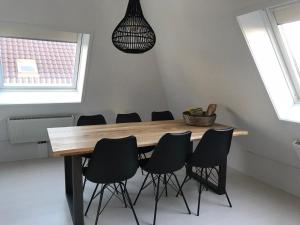 卡兰茨奥赫Dorpsweg 18 nummer 7的用餐室配有木桌和黑椅子