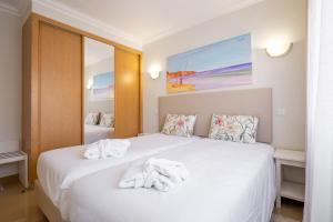 拉戈斯Boavista Golf & Spa - Bela Colina Village的卧室配有白色床和毛巾