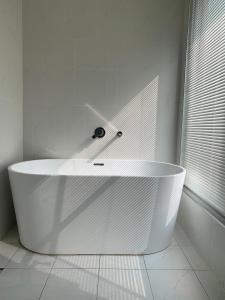 Zhongpu里山下民宿的白色浴室设有白色浴缸,浴室设有窗户