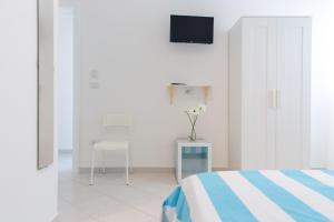 托雷拉皮罗Vidamarina - Camere al Mare的卧室配有一张床,墙上配有电视。