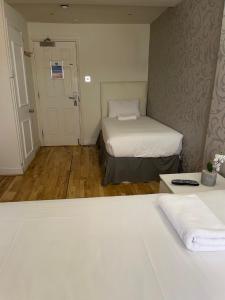 伦敦百乐门酒店的小房间设有两张床和一扇门