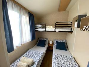 韦莱涅Hiška Štefi Velenjsko jezero的小房间设有两张双层床,配有蓝色枕头