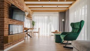 拉布卡Dolina Barw - całoroczne domki na wynajem的客厅配有绿色椅子和电视