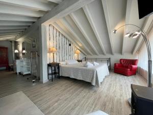 朗格勒La Posada de Langre Anexo的一间卧室配有一张床和一张红色椅子