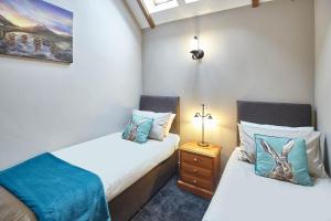 LivertonHost & Stay - Low Waupley Farm的一间卧室设有两张床和床头柜