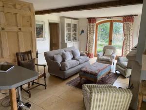 斯特劳德COTSWOLD ESCAPE WITH SWIMMING POOL NEAR CHELTENHAM的客厅配有沙发、椅子和桌子