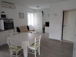 波斯蒂拉Apartment Perica - 10 m from sea的厨房以及带桌椅的用餐室。