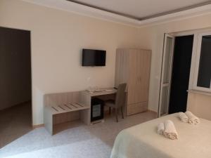 特罗佩阿Vittorio Veneto Accomodation - Tropea city center的客房设有两张床、一张桌子和一台电视。