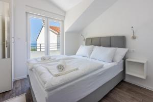 塞尔瑟Luxury Apartments Lovorka 3 & 4***/****的白色卧室设有一张大床和窗户