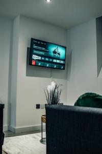 布雷得佛Bv Cosy Basement Apartment At Conditioning House的客厅的墙上设有平面电视