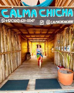 圣玛尔塔Calma Chicha的一位妇女沿着木走廊走,手持标志