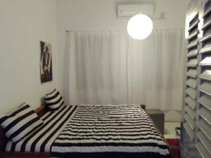 AdaEzime Guesthouse And Pizzeria的一间卧室配有一张带黑白条纹毯子的床