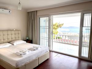 博德鲁姆BODRUM BURCU VILLA , Magnificent Sea View, Cozy, Free Otopark, Free Wifi的一间卧室设有一张床和一个大型滑动玻璃门
