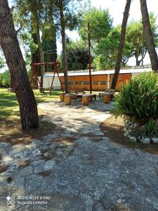 科佩尔蒂诺casa vacanze Riccardo Elisa的公园内有长椅和树木的游乐场