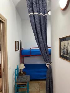 科佩尔蒂诺casa vacanze Riccardo Elisa的一间设有蓝色双层床和窗帘的房间