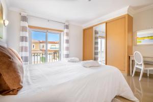 拉戈斯Boavista Golf & Spa - Bela Colina Village的白色的卧室设有一张大床和一个窗户