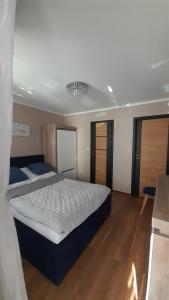 米兹多洛杰Kwatery prywatne的卧室配有一张白色的大床,铺有木地板