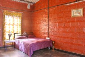 纳西克SiddhaDham - Farm Stay Cottage 1的一间卧室设有一张床和砖墙