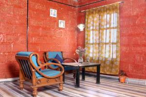 纳西克SiddhaDham - Farm Stay Cottage 1的一间设有椅子和桌子的房间和红砖墙