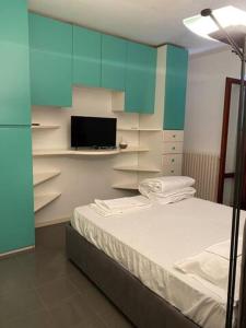Casal TauleroVilla Cycas的一间卧室配有一张床、一台电视和蓝色橱柜。
