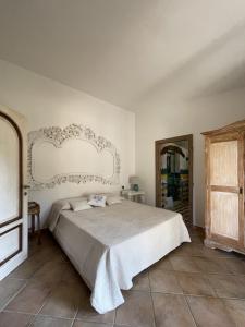 奥尔比亚Villa Smeralda的一间卧室配有一张带白色床头板的大床