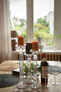 奥勒松Light Sentral Apartment Ålesund的一张桌子,上面放着两根蜡烛和一瓶葡萄酒