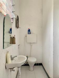 姆万扎Mambo & Jambo House的一间带水槽、卫生间和镜子的浴室