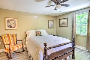 查塔努加Secluded Chattanooga Getaway with Deck and Yard!的一间卧室配有一张床、风扇和椅子
